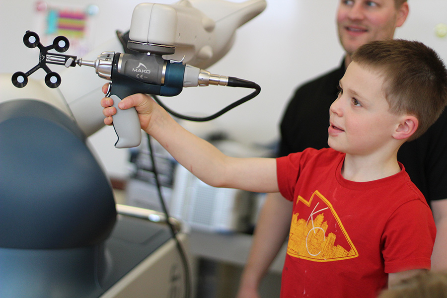 Boy steering Mako robotic arm in the Maker Studio