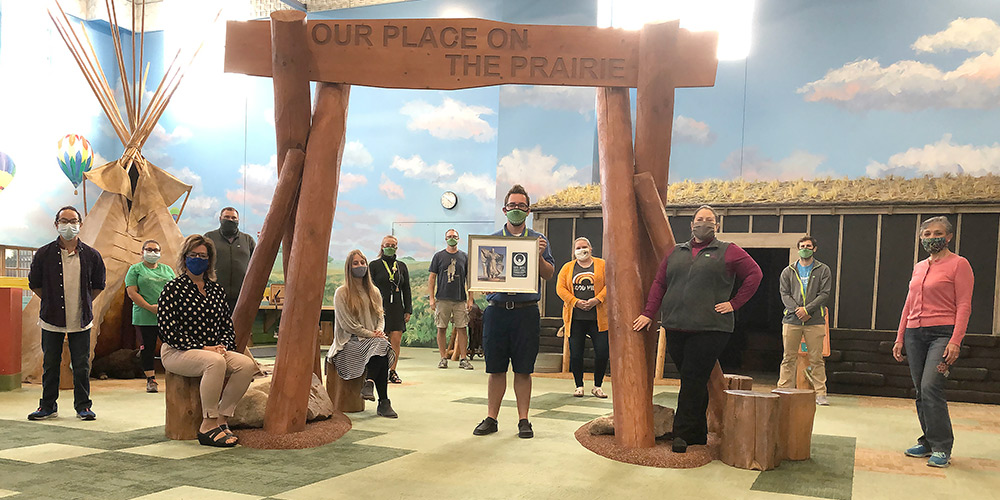Children's Museum of South Dakota staff pose on the indoor prairie with the Distinguished Achievement in the Humanities Award.