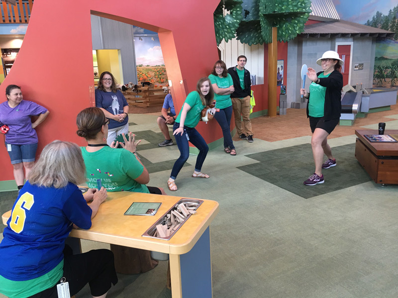 Group of adults acting mid-move action shot on prairie of children's museum