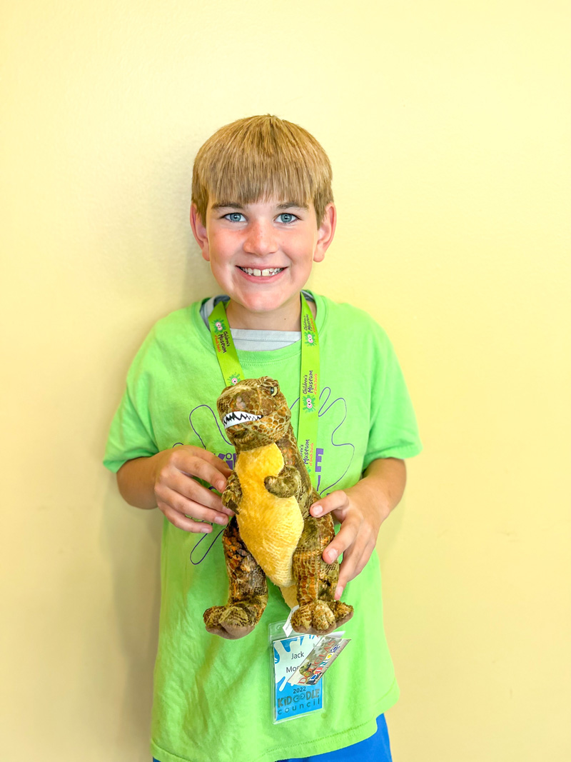 boy holding a plush t-rex dinosaur