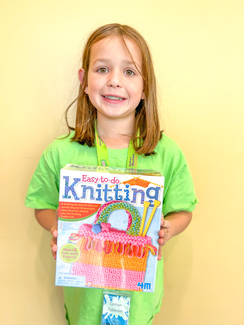 girl holding a knitting kit