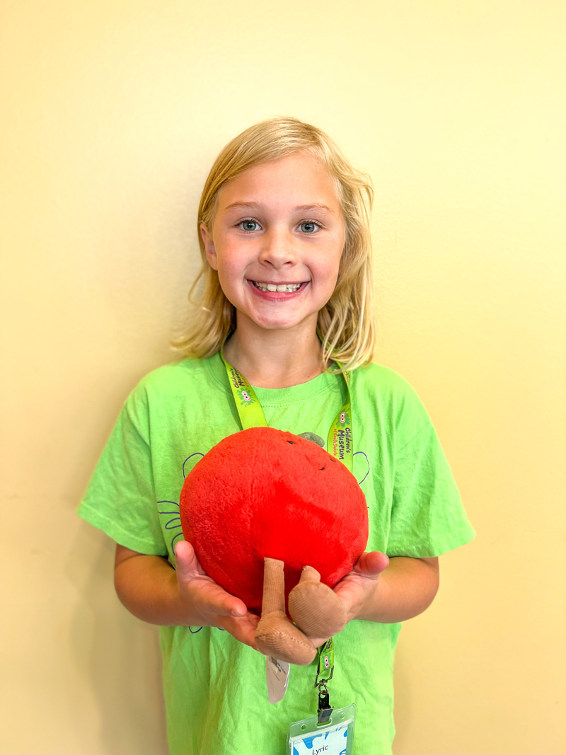 girl holding plush tomato