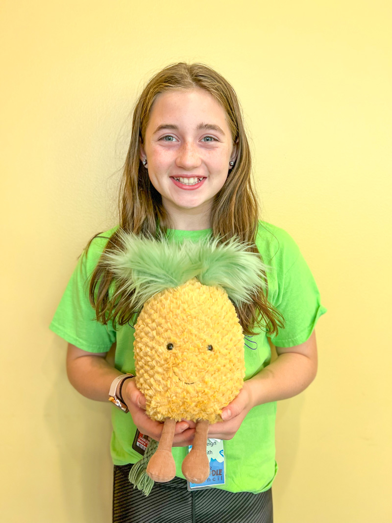 girl holding a plush pineapple
