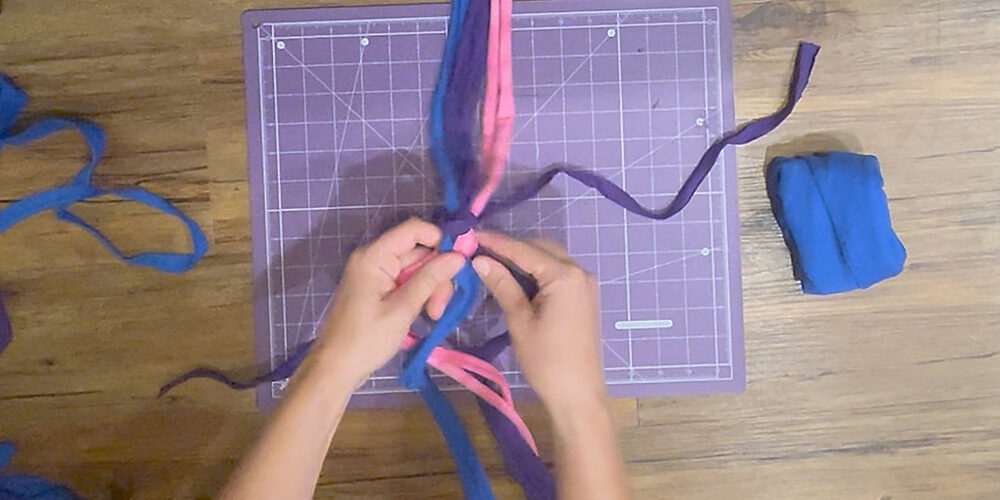 Separate strips into three sections and begin to braid tightly. Grab the right section with your right hand and the left section with your left hand. Cross the left section over the middle section. Then cross the right section over the middle section. Repeat until you are about finished braiding the middle third.