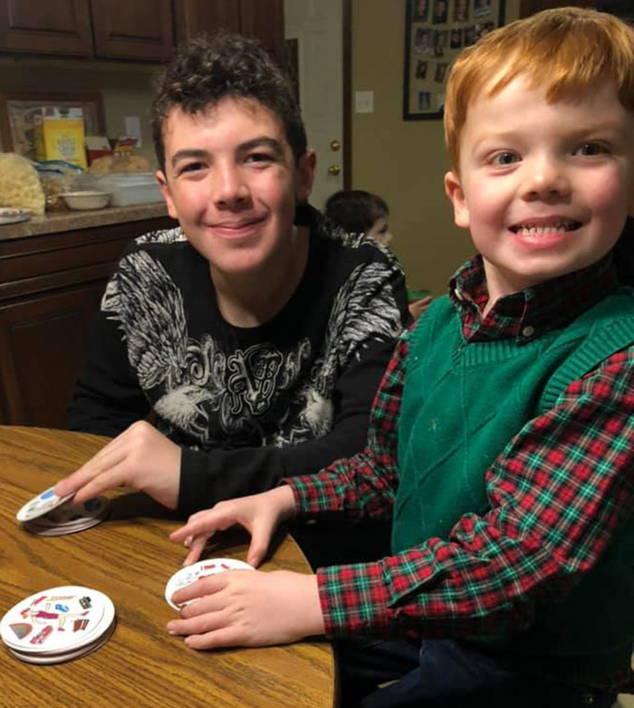 Two boys smile while playing Spot It.