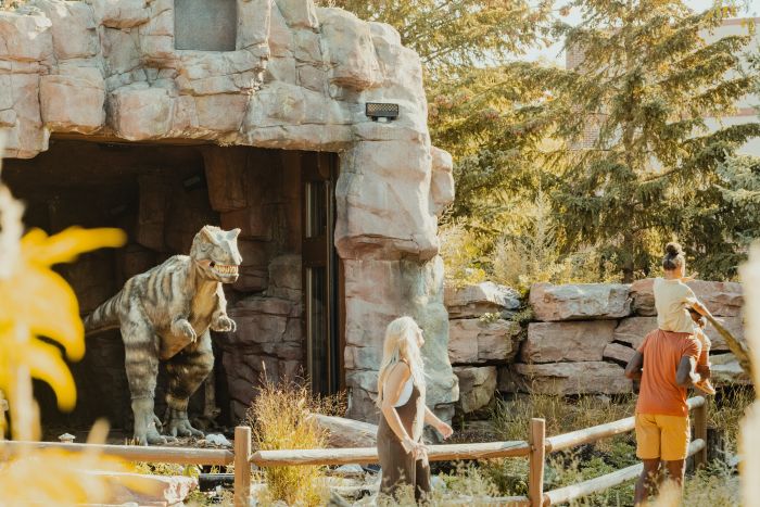 family walking on the outdoor prairie in front of our baby T. rex Max