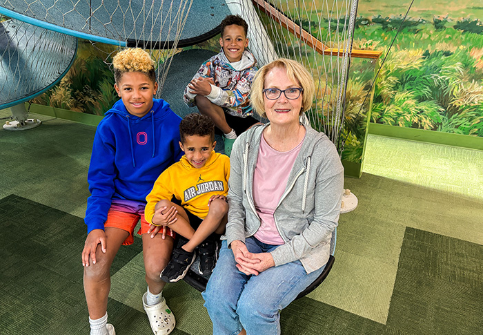 grandmother and her three grandson in the Cloud Climber exhibit
