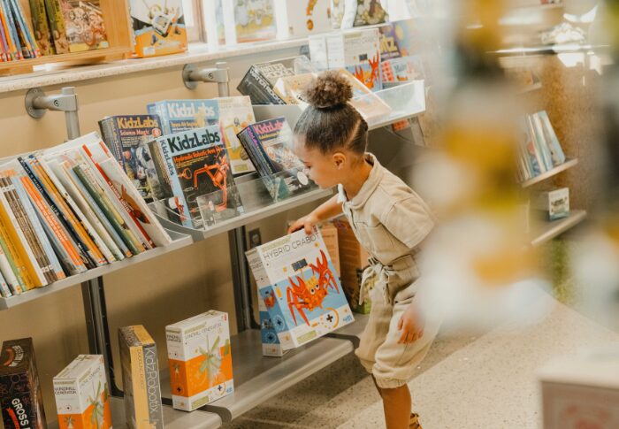 little girl picking out a souvenir toy in the gift shop