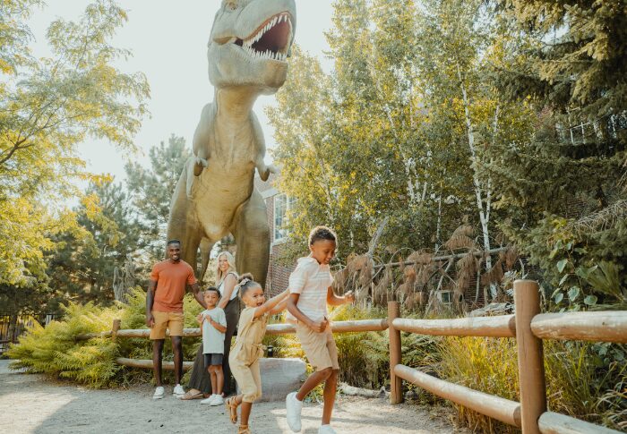 family playing in front of life-size Mama T. Rex