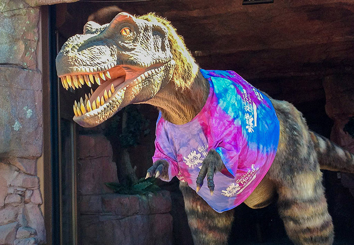 Animatronic dinosaur wearing a tie-dye tshirt. 